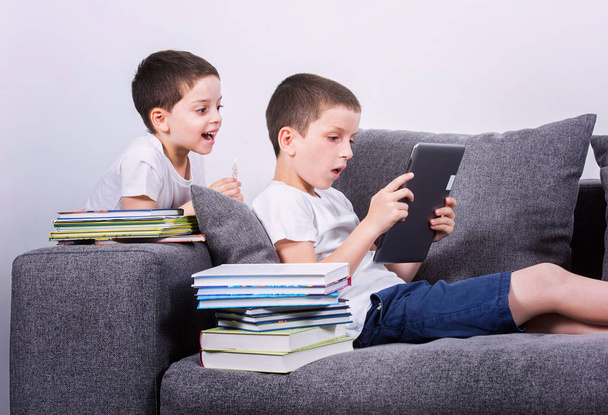 Boys using a tablet PC on the sofa.  - Photo, Image