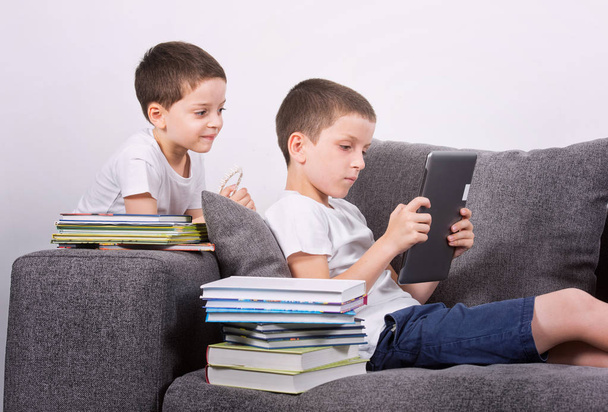 Boys using a tablet PC on the sofa. - Foto, Imagem