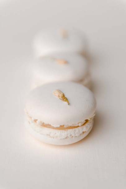 Sweet white macaroons on white table background. - Foto, afbeelding