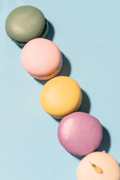 Five sweet colorful macaroons on blue table background. - Foto, Bild