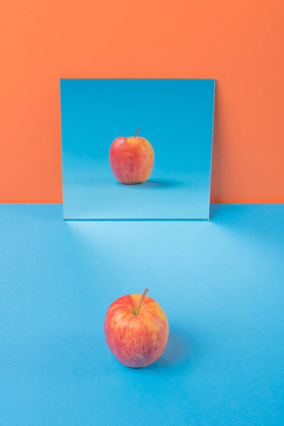 Apple on blue table isolated over orange background - Photo, Image