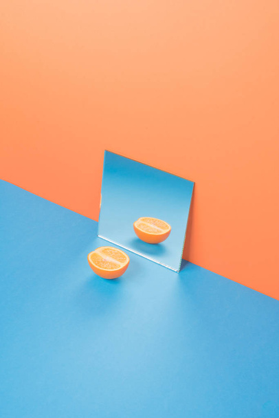 Orange on blue table isolated over orange background - Valokuva, kuva