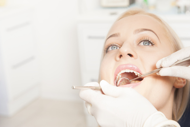 Zbliżenie kobieta dentysty badanie połowy dorosłego pacjenta - Zdjęcie, obraz