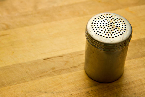 Pepper shaker on a wooden counter - Fotó, kép