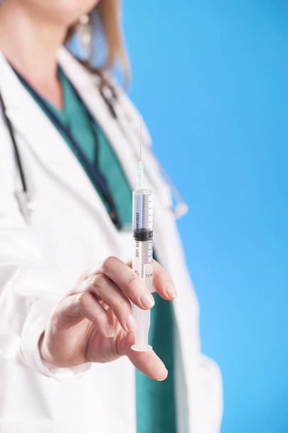 Médecin tenant une seringue d'injection médicale et un stéthoscope
 - Photo, image