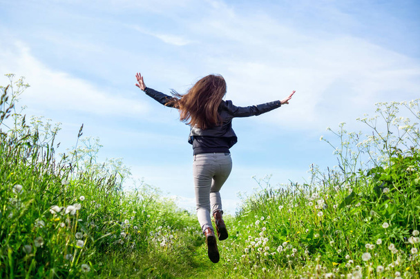 Happy girl running through summer meadow towards the nature - Photo, Image