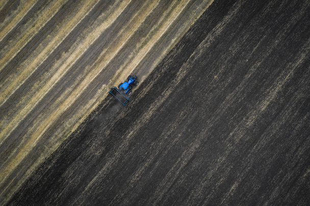 Tractor cultivating field at spring, aerial view - Foto, afbeelding