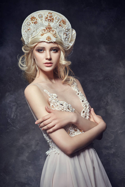 Tiara crown on head blonde girl. Woman in fairy dress, mysterious magical fairy. Ethnic blond woman on gray background. - Foto, Imagem