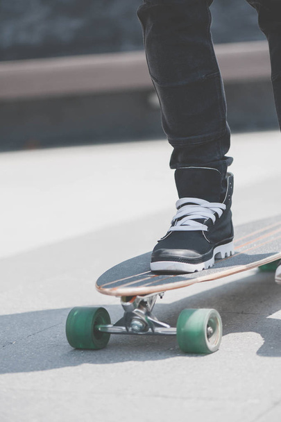 Close up of skater's legs on the longboard riding at the street in outdoors - Photo, Image