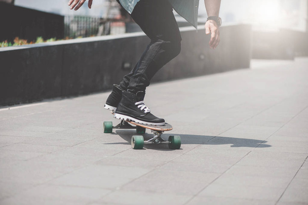 Close up of skater's legs on the longboard riding at the street in outdoors - Foto, Bild