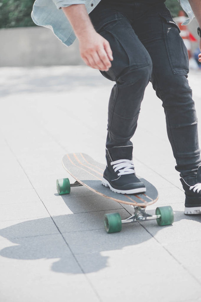 Close up of skater's legs on the longboard riding at the street in outdoors - Fotó, kép