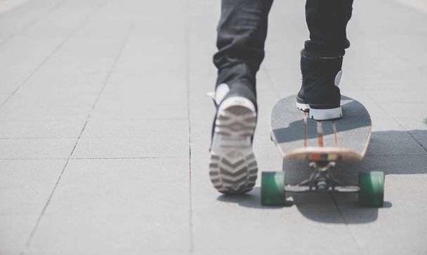 Close up of skater's legs on the longboard riding at the street in outdoors - Valokuva, kuva