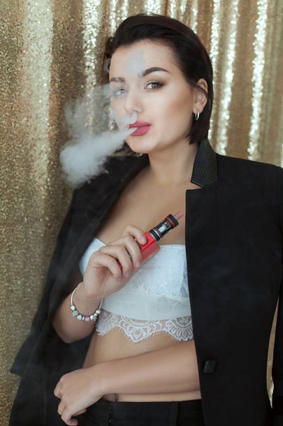 Γυναίκα που καπνίζει ένας ηλεκτρονικός ναργιλές. - Φωτογραφία, εικόνα