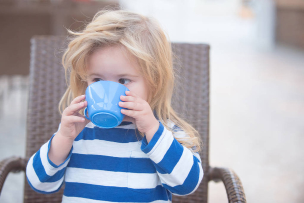 Boy drinking milk from blue cup - Foto, Imagen