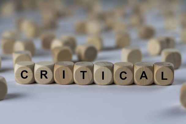 critical   cube with letters, sign with wooden cubes - Foto, imagen