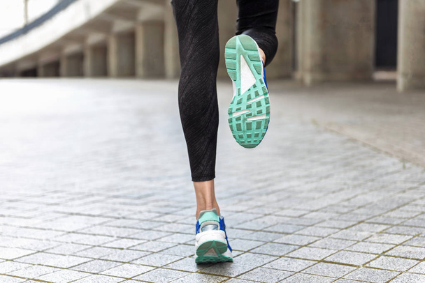 Feet of young woman jogging outside - Photo, Image