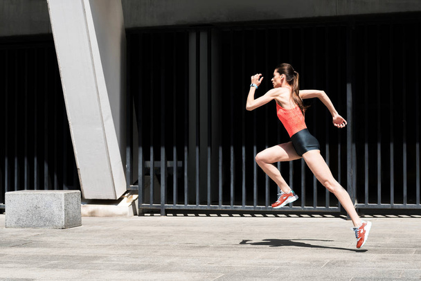 Confident young woman jogging outside - Foto, Imagen