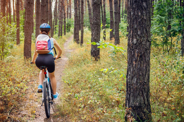 молодая женщина на велосипеде в лесу - Фото, изображение