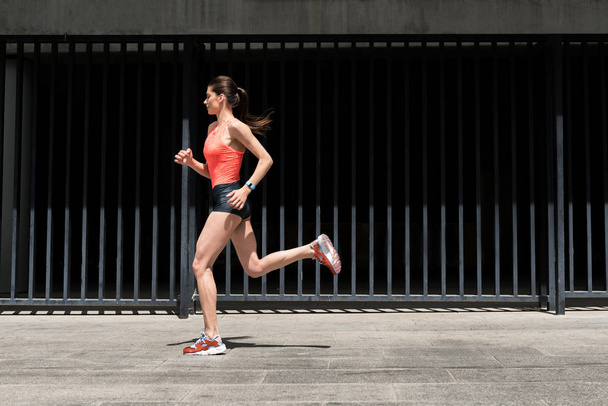 Fit young woman jogging on street - Foto, Bild