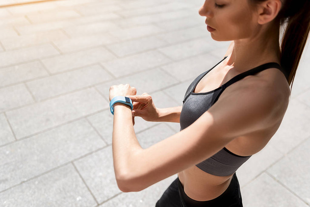 Calm sporty girl using smartwatch for workout - Fotoğraf, Görsel
