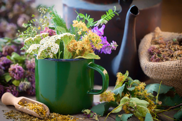 Enameled mug of summer healing herbs, old tea kettle and medicinal plants for healthy herbal tea. Herbal medicine. - Fotoğraf, Görsel