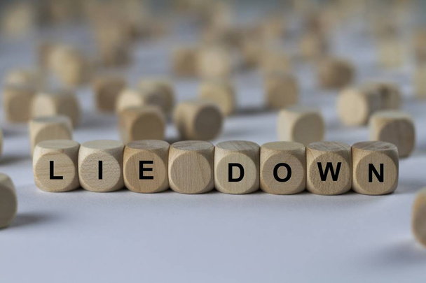lie down   cube with letters, sign with wooden cubes - Photo, Image