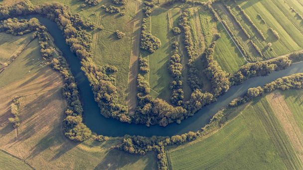 River bend surrounded by fields from birds eye view. - Foto, Imagen