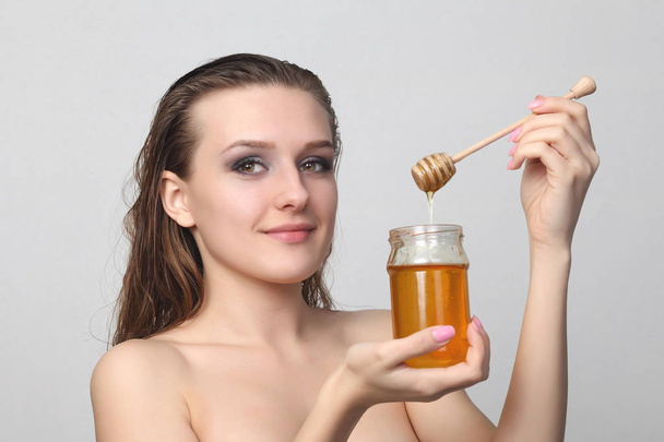 Hermosa mujer con miel en la cara
 - Foto, imagen