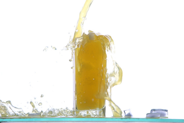 Lemon juice glass with lemon slice, with juice splash, isolated on white background. - Photo, Image