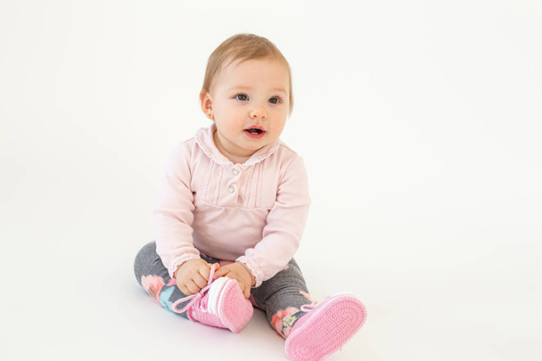 Cute little baby girl sitting on floor isolated - Foto, immagini