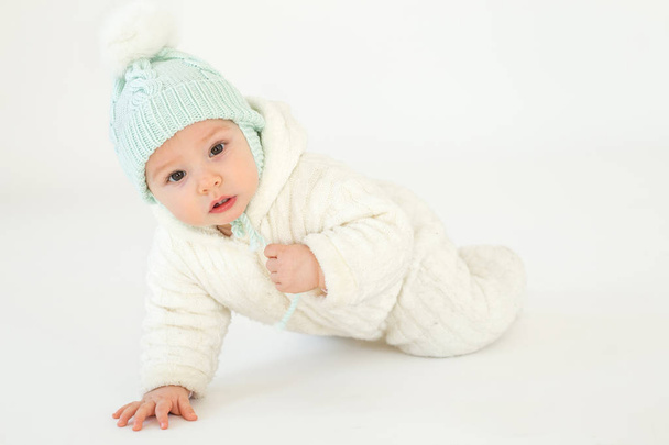 Niedliches kleines Baby mit Hut auf dem Boden sitzend - Foto, Bild
