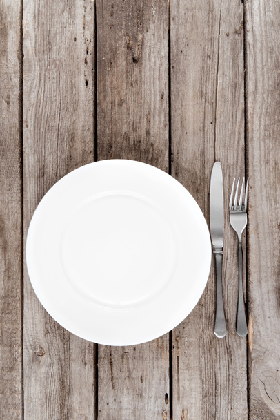 пустая тарелка и столовое серебро на столе
 - Фото, изображение