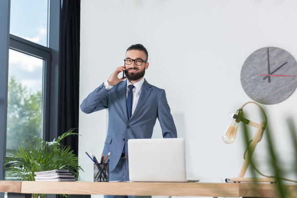 hombre de negocios hablando en smartphone en el lugar de trabajo
 - Foto, imagen