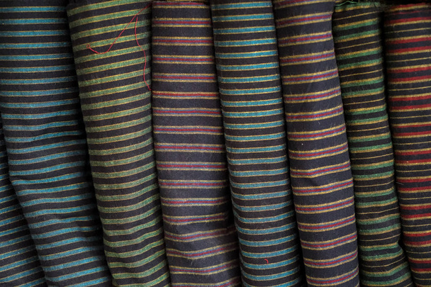 Ряд традиционных полос тканевых рулонов в местном магазине
 - Фото, изображение
