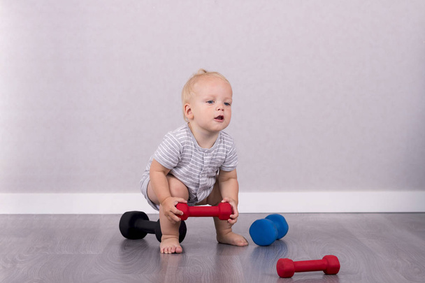 Cute toddler lifting a weight like a professional athlete - Fotografie, Obrázek