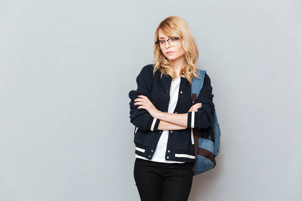 Sad young lady student wearing glasses with backpack - Fotografie, Obrázek