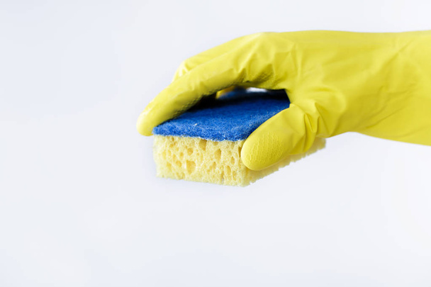 hand in rubber yellow glove holding sponge on white background. cleaning - Photo, image