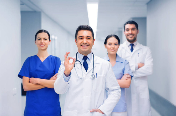 group of medics at hospital showing ok hand sign - 写真・画像