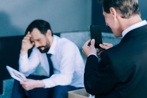 businessman with smartphone photographing fired colleague - Photo, Image