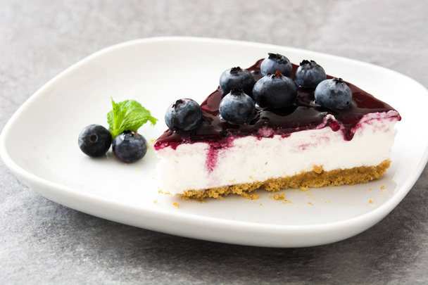 Stuk van blueberry cheesecake op houten tafel - Foto, afbeelding
