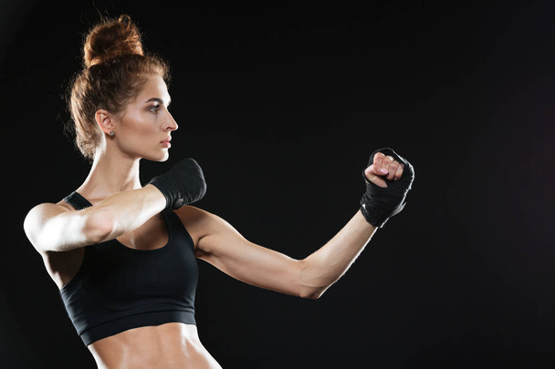 Side view of Concentrated female fighter ready to fight - Photo, Image