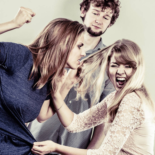 Aggressive mad women fighting over man. - Foto, afbeelding