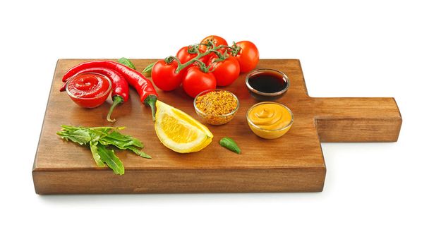 Wooden board with different sauces and vegetables on white background - Foto, Imagem