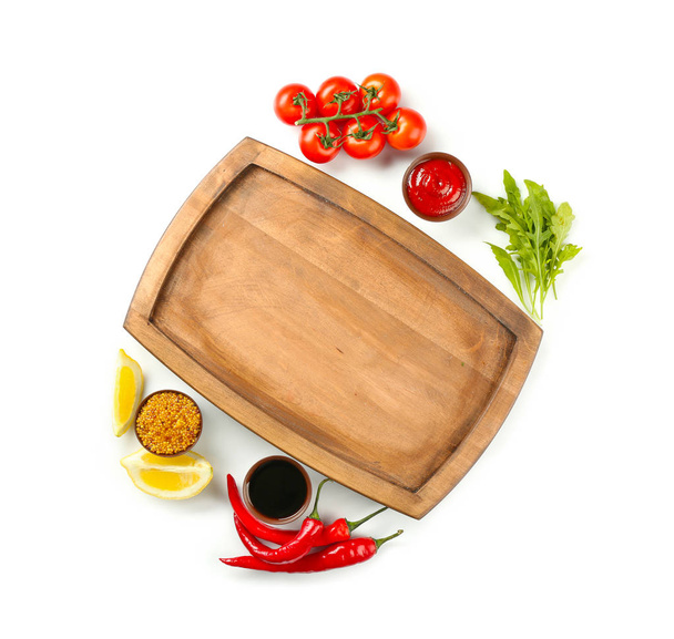 Composition with wooden plate and different sauces on white background - Foto, immagini