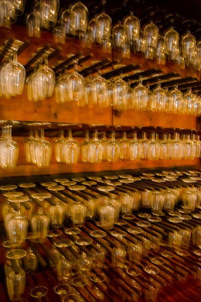 Fileiras de borrão de movimento de copos de vinho vazios na vitrine
.  - Foto, Imagem