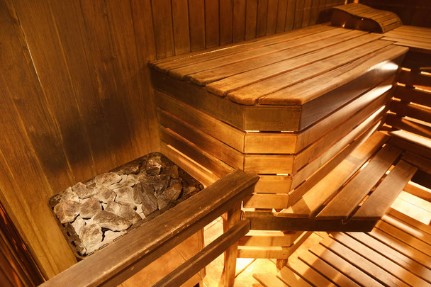Kocioł z gorącymi kamieniami i drewniane ławki w saunie - Zdjęcie, obraz