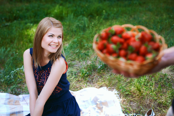 man gives a girl a basket with strawberries - Φωτογραφία, εικόνα