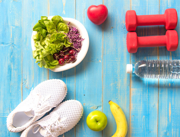 Healthy lifestyle sport equipment fitness, sneakers, green apple, fresh water and healthy food on blue wood background.  Healthy Concept. - Foto, Bild