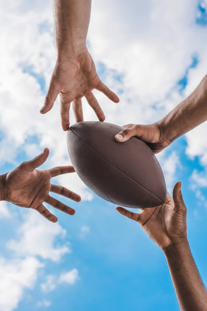 hands holding american football ball  - 写真・画像