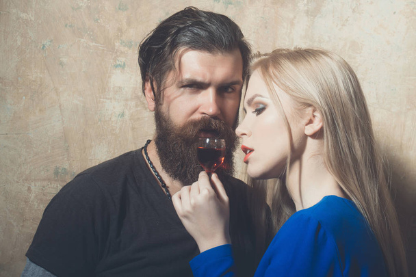 Hipster and woman relaxing with glass of red liqueur - 写真・画像